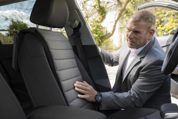 Man looking at Smart Massage Cover in the car